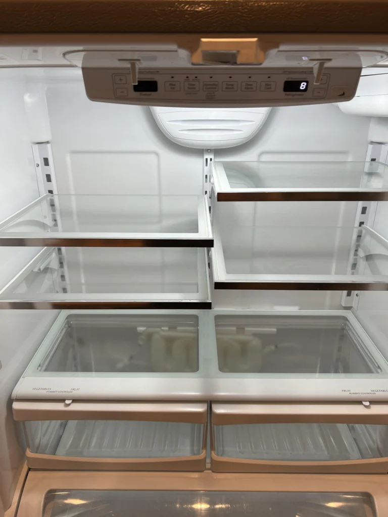 Spotless refrigerator interior with clean glass shelves, clear drawers, and freshly wiped compartments ready for groceries.