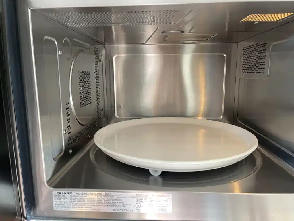 Clean stainless steel microwave interior with a wiped-down turntable, polished inner walls, and a fresh, ready-to-use finish after professional appliance cleaning.