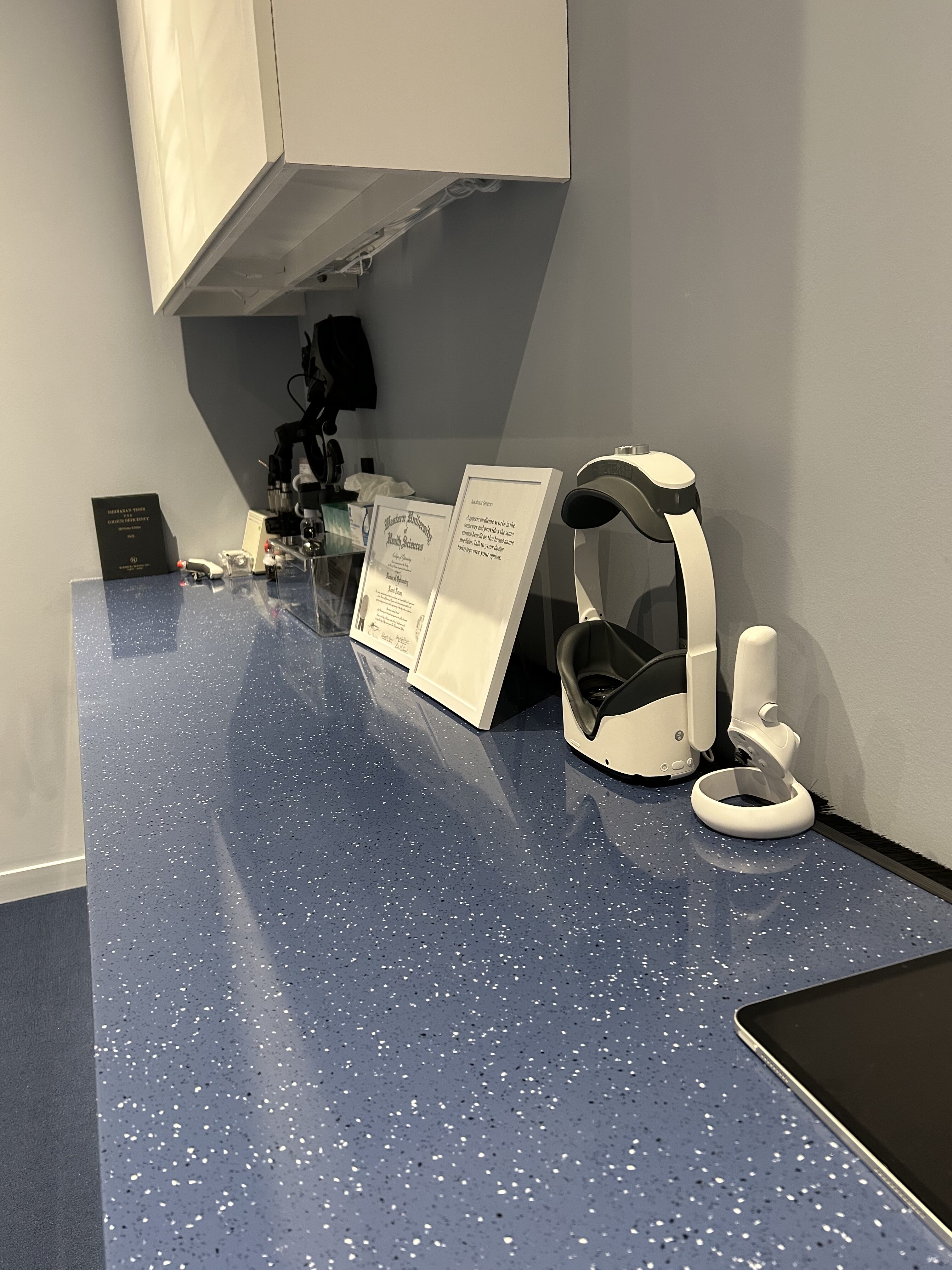 Eye exam equipment and diploma on an optometry office counter.
